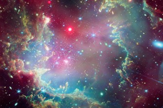 A star cluster inside of satellite galaxy that seems to be giving off a pink, purple, and blue glow.